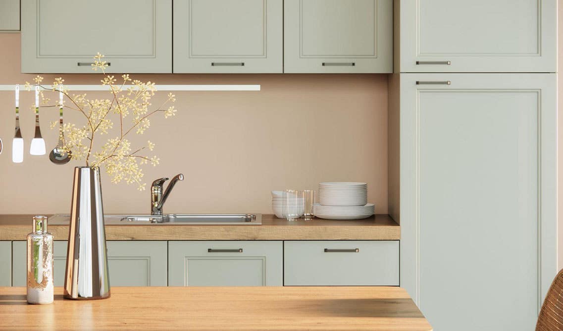 farmhouse kitchen idea with sage green kitchen cabinets, wooden countertop, shiny flower vase