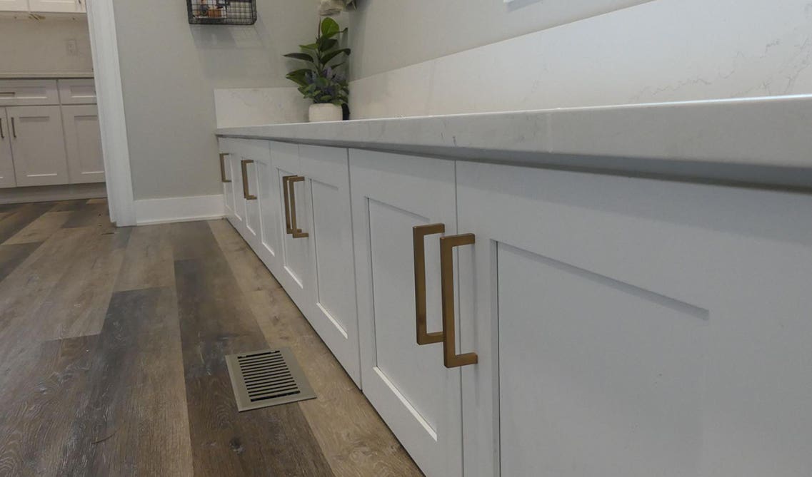 mudroom design ideas with base white cabinets with gold hardware