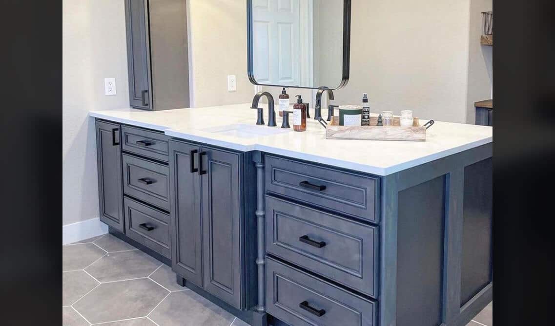 Grey bathroom vanity with white wall and white countertop