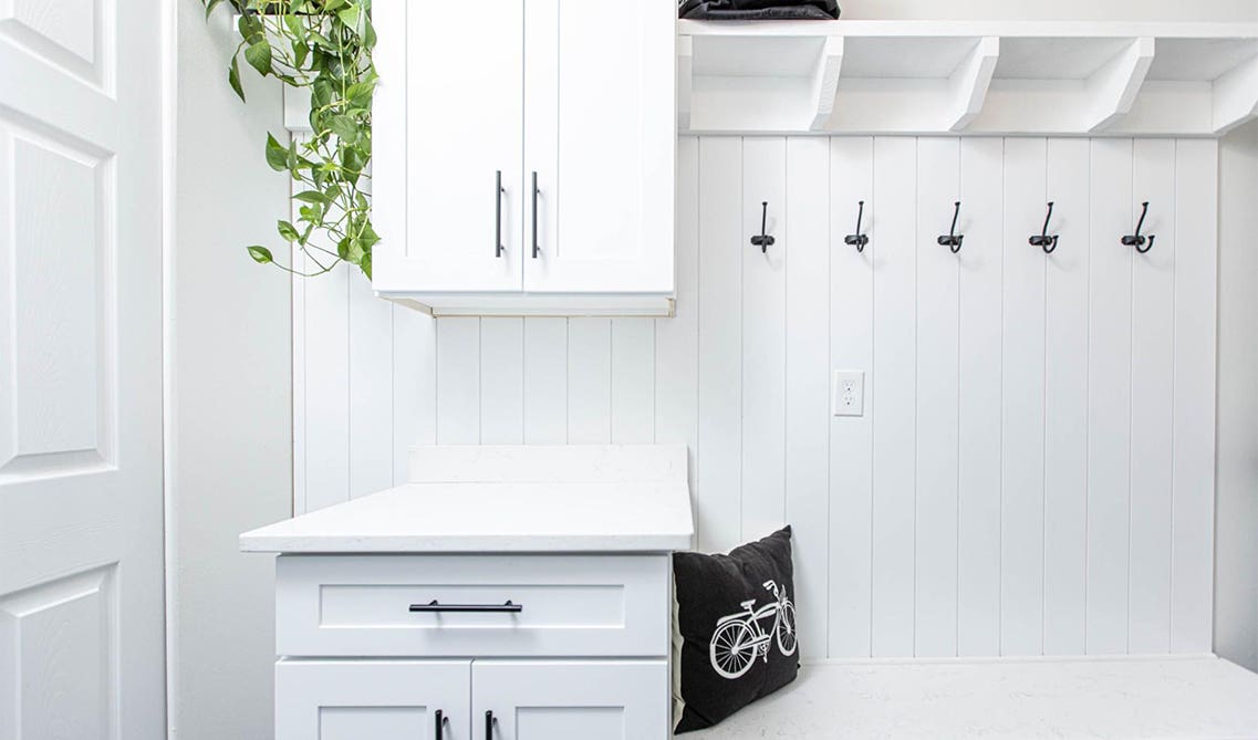 Mudroom with Drawers and built-in cabinets with black hardware, side bench, black pillow