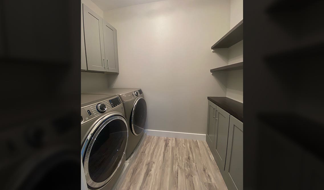 Gray cabinets with laundry machine 