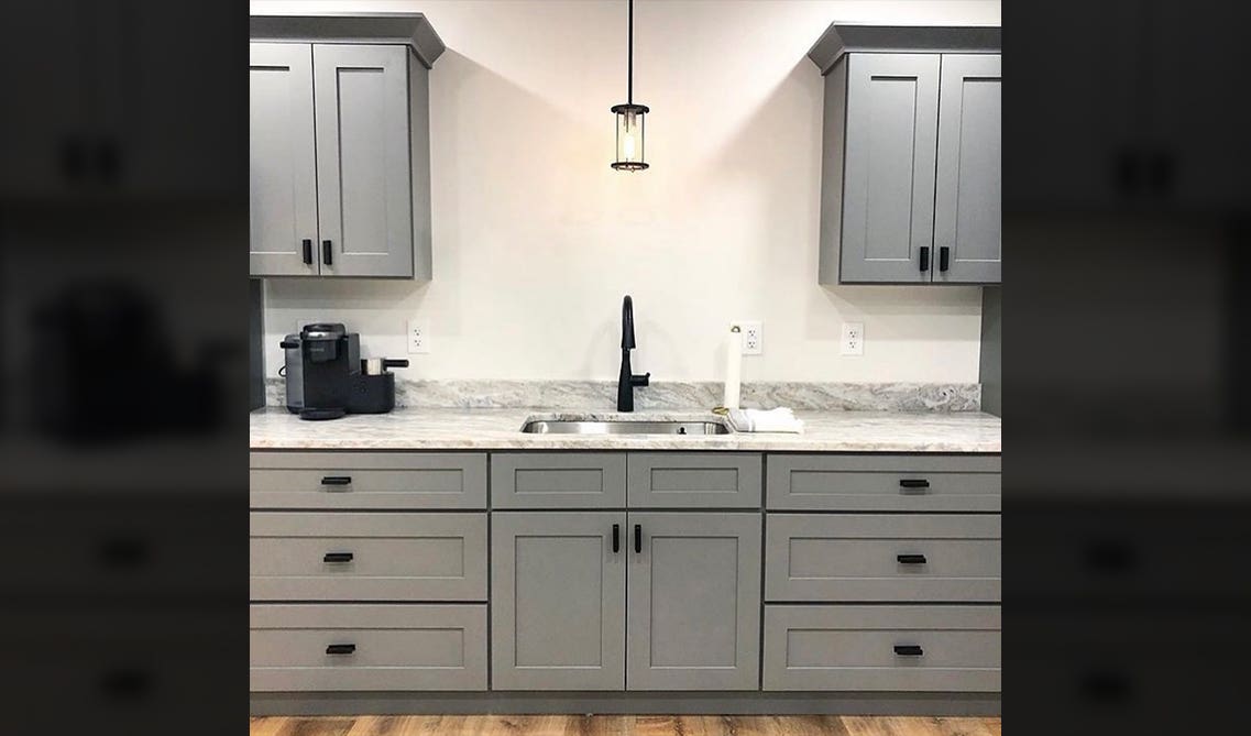Grey-colored cabinets pair well with black and stainless steel hardware