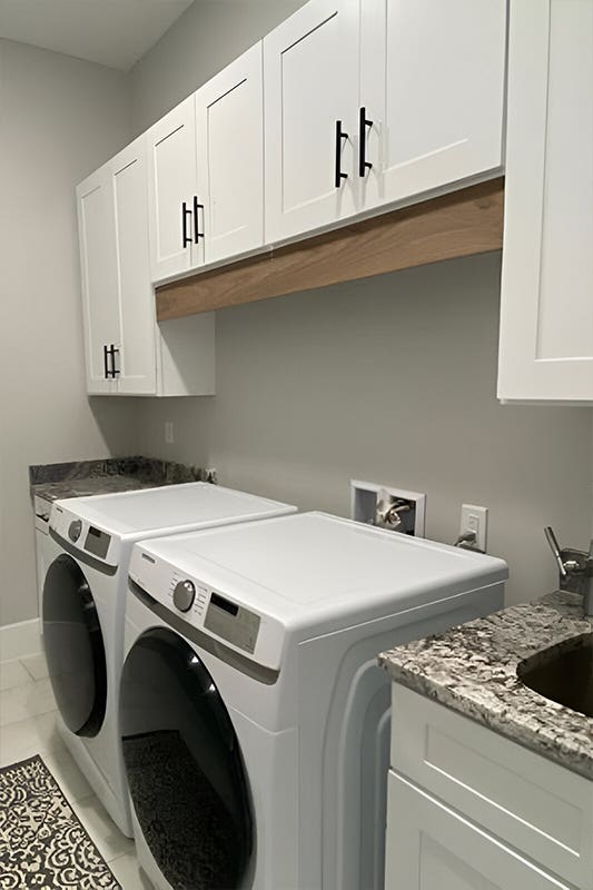Laundry room with white storage cabinets and washer, dryer 