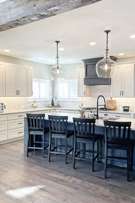 Black kitchen island paired with Chairs and integrated sink