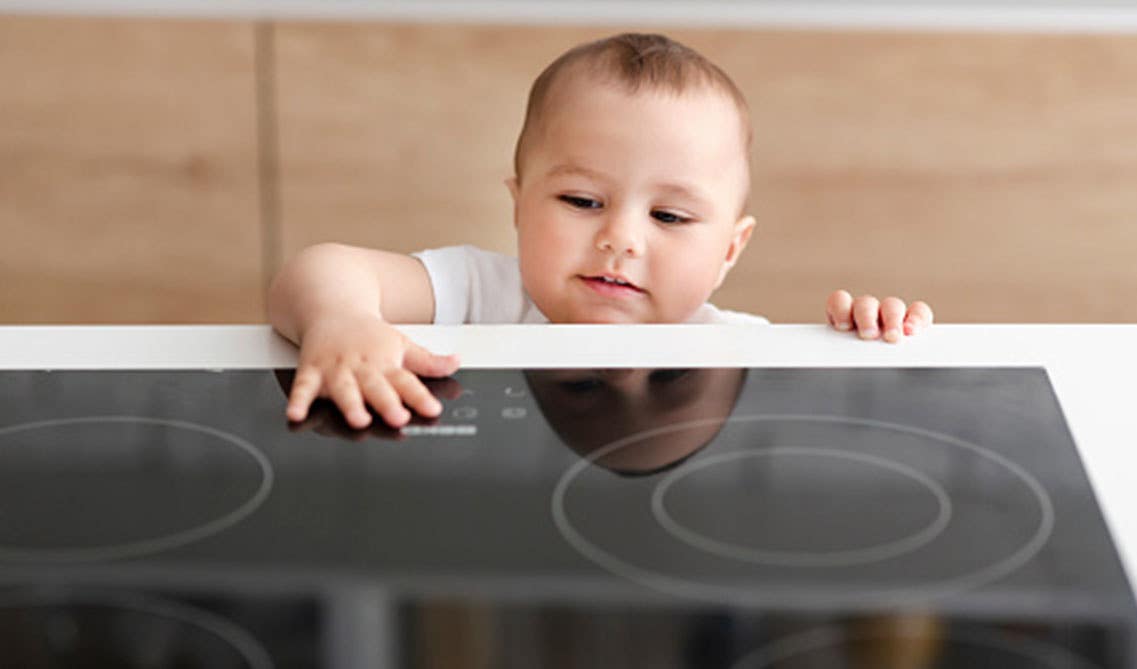 Cute little baby with electric stove