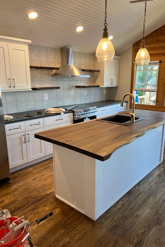 Kitchen with white cabinets and wood countertop and wall