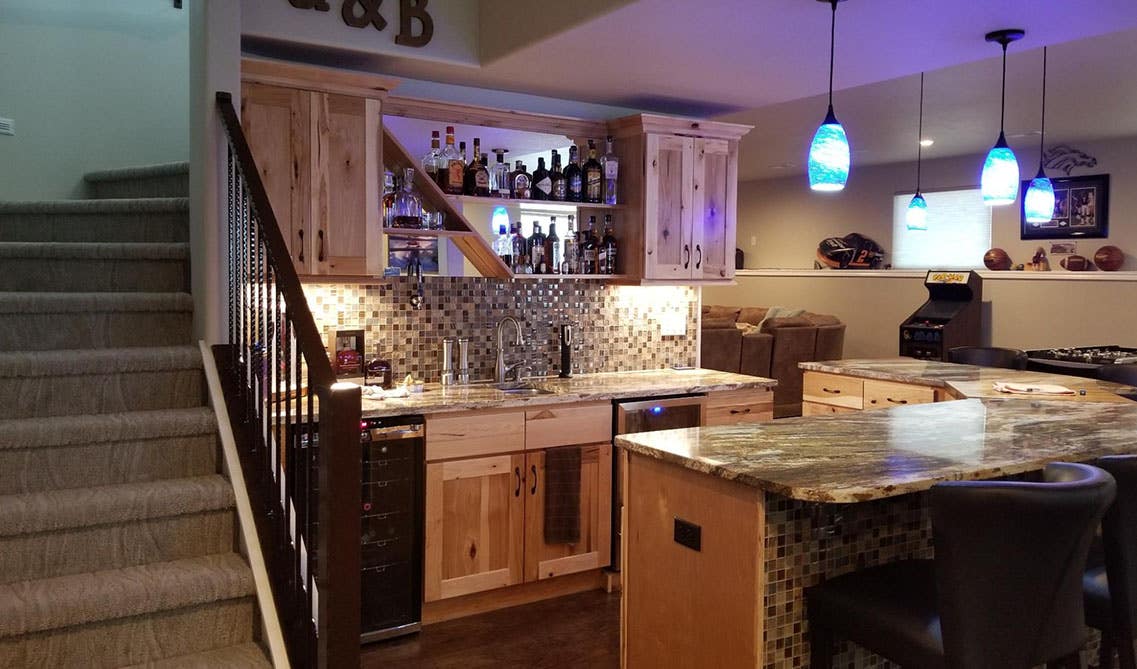 kitchenette bar with natural cabinets, marble countertop, pendant lights and open shelves