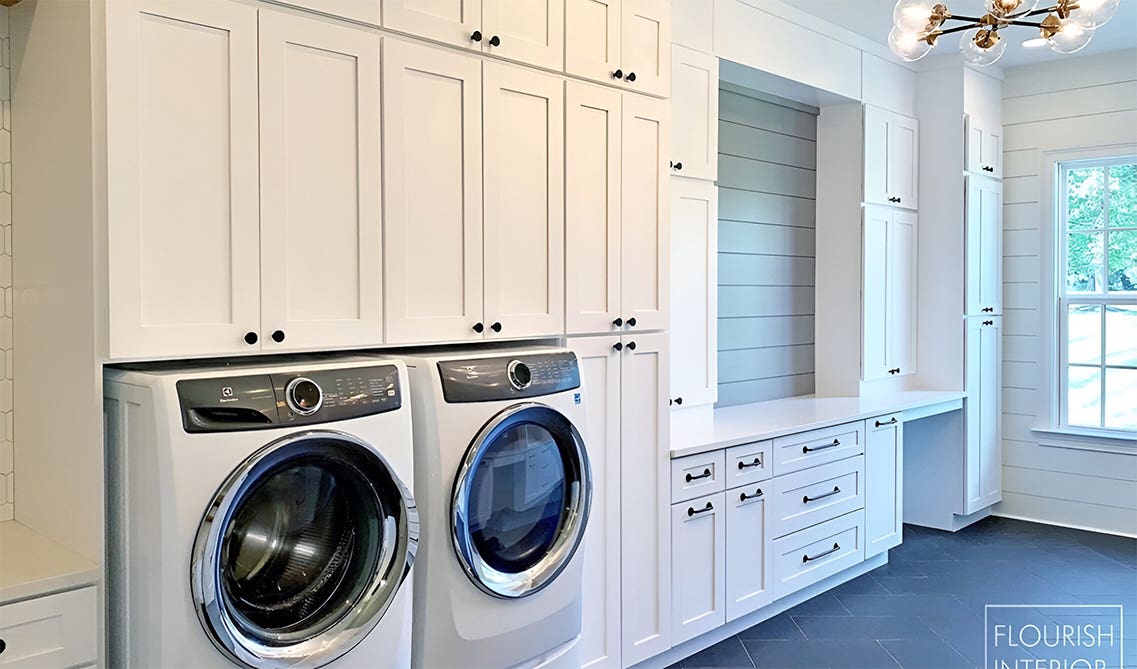Laundry room with white storage cabinets and decorative lighting fixtures
