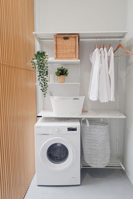 Laundry room with washer and floating shelves for storage and cloth hanger, basket 