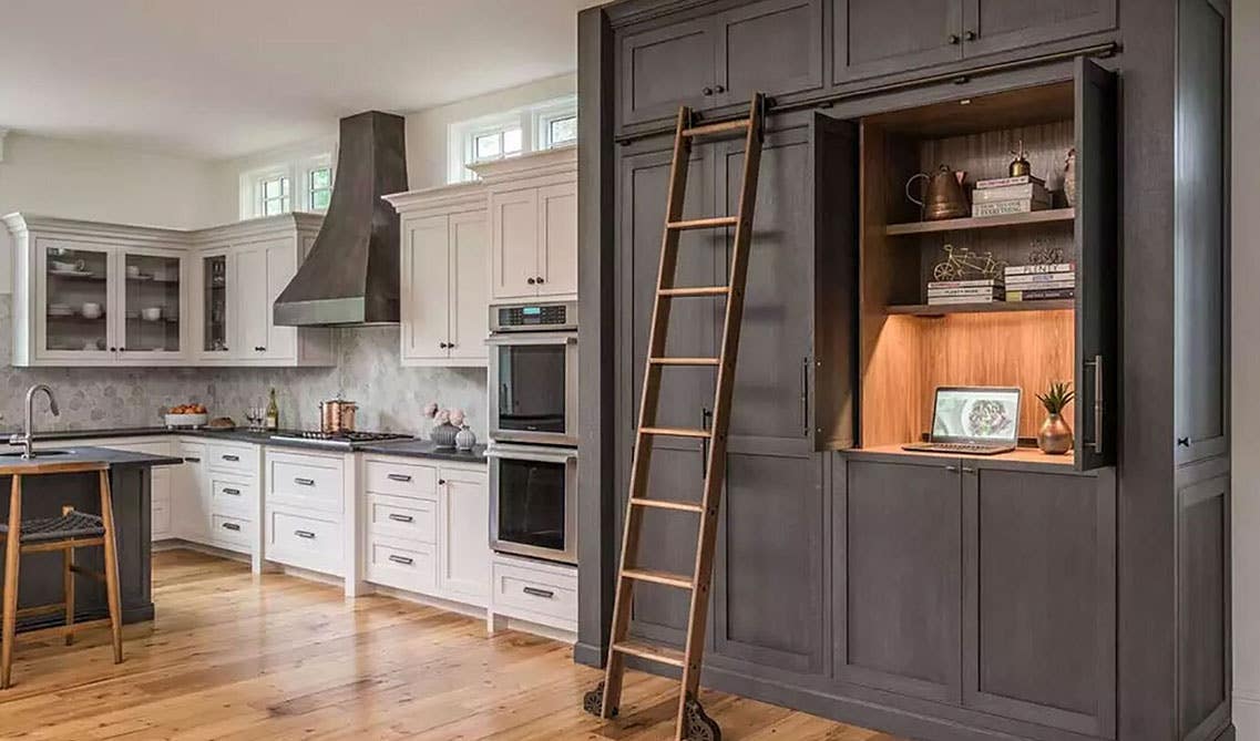 Open kitchen concept with two tone cabinets and library ladder