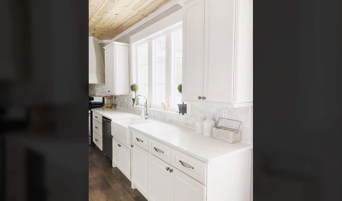 All white Modern kitchen style with shaker cabinets, stainless steel hardware, SPC Flooring and large window