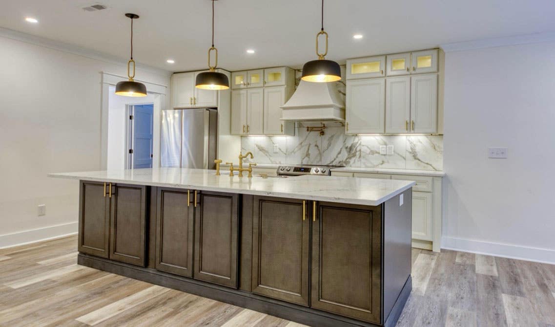 Luxury kitchen design with two tone cabinets, large island and pendent light