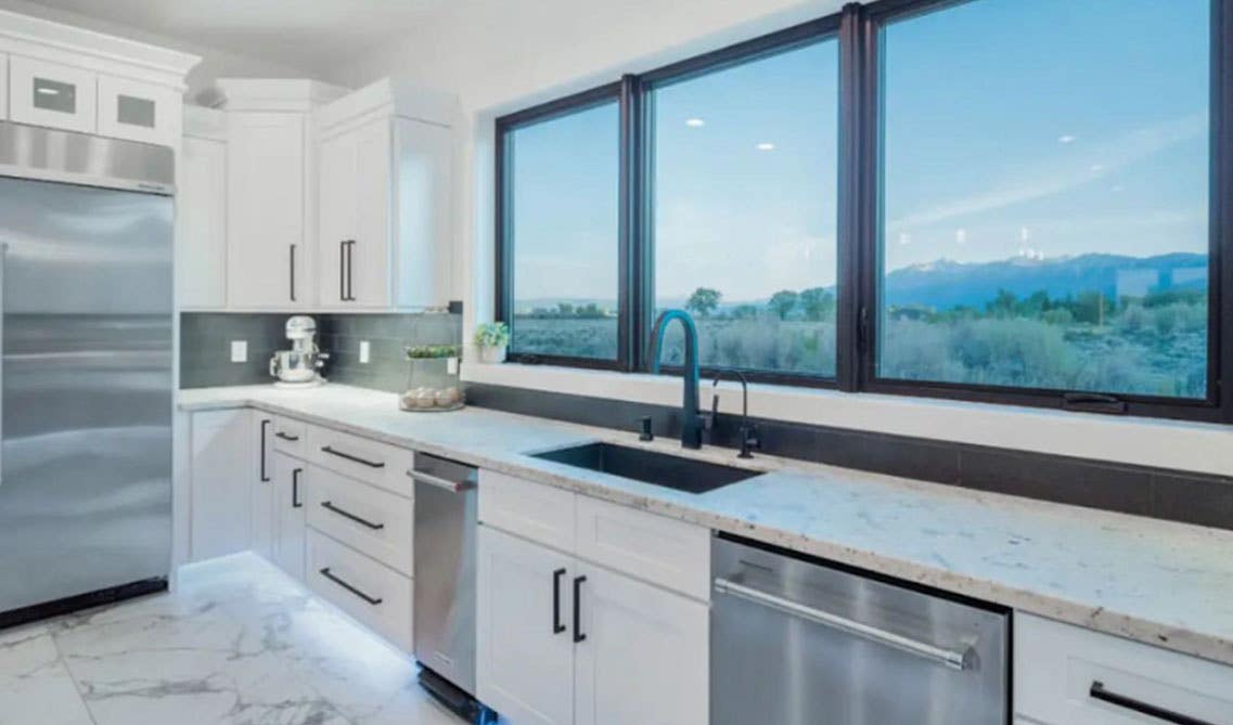 modern kitchen with white cabinets, countertop with integrated sink, matt black fitting and fixture and one large window