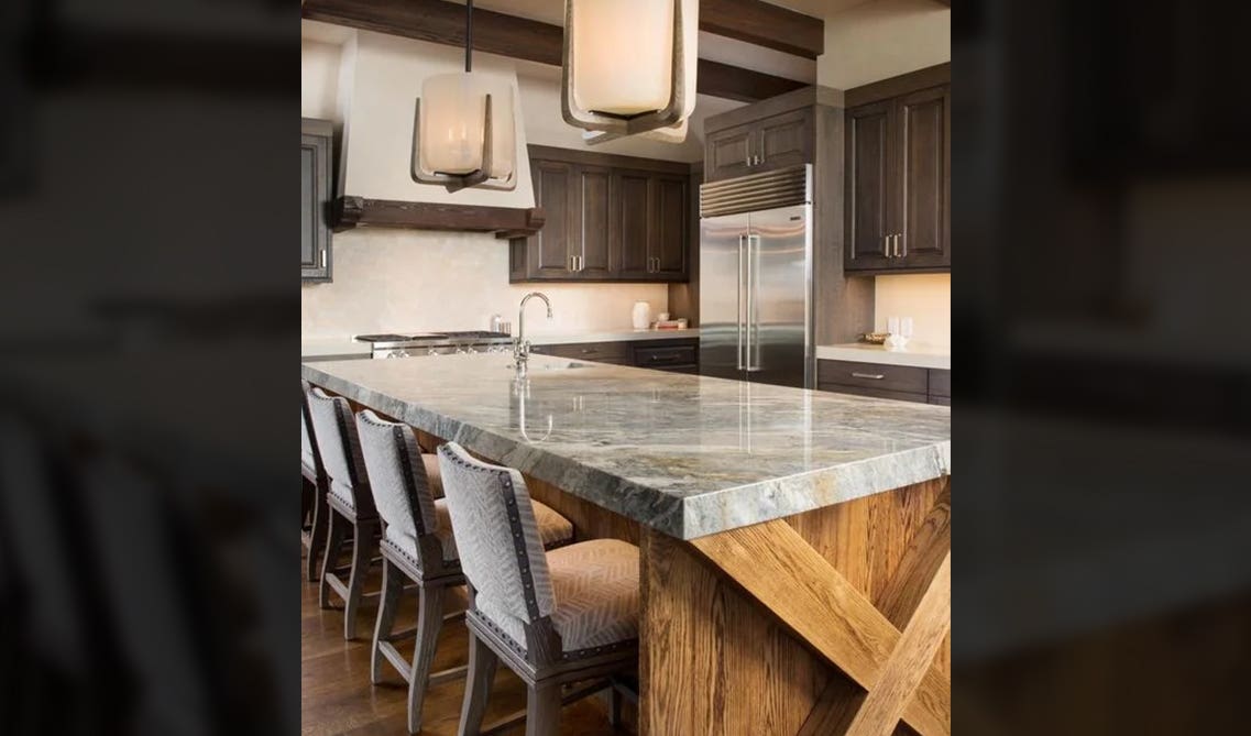 mountain kitchen features sleek black shaker cabinets with large wood beams, a natural stone accent wall, and plenty of overhead lighting