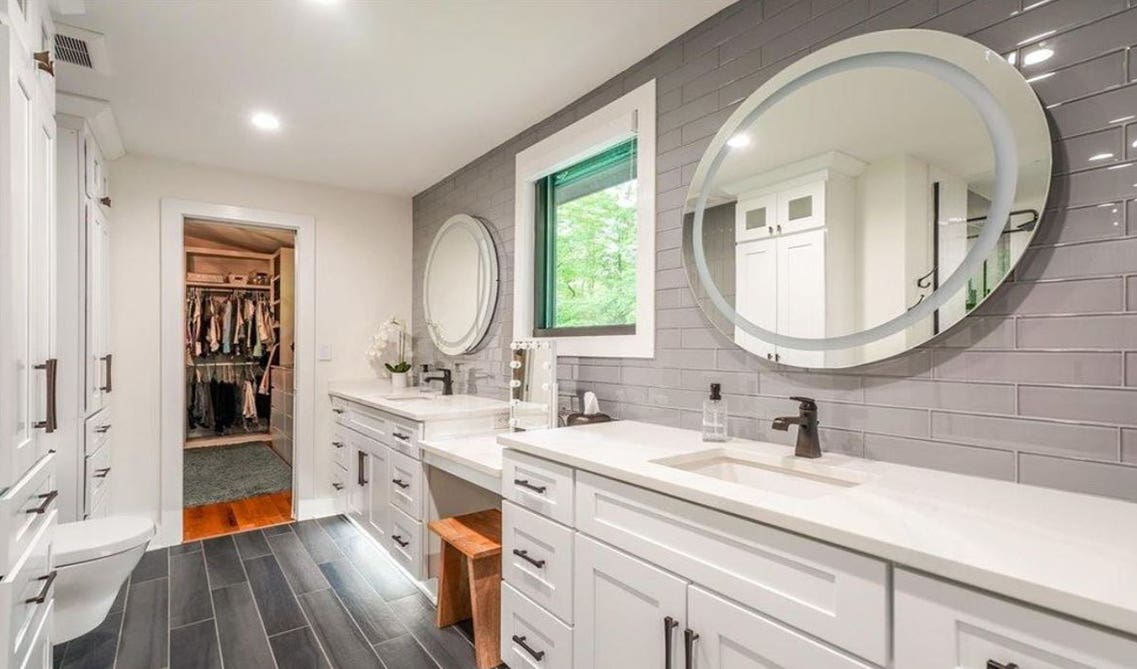 white bathroom vanities with large mirror and window