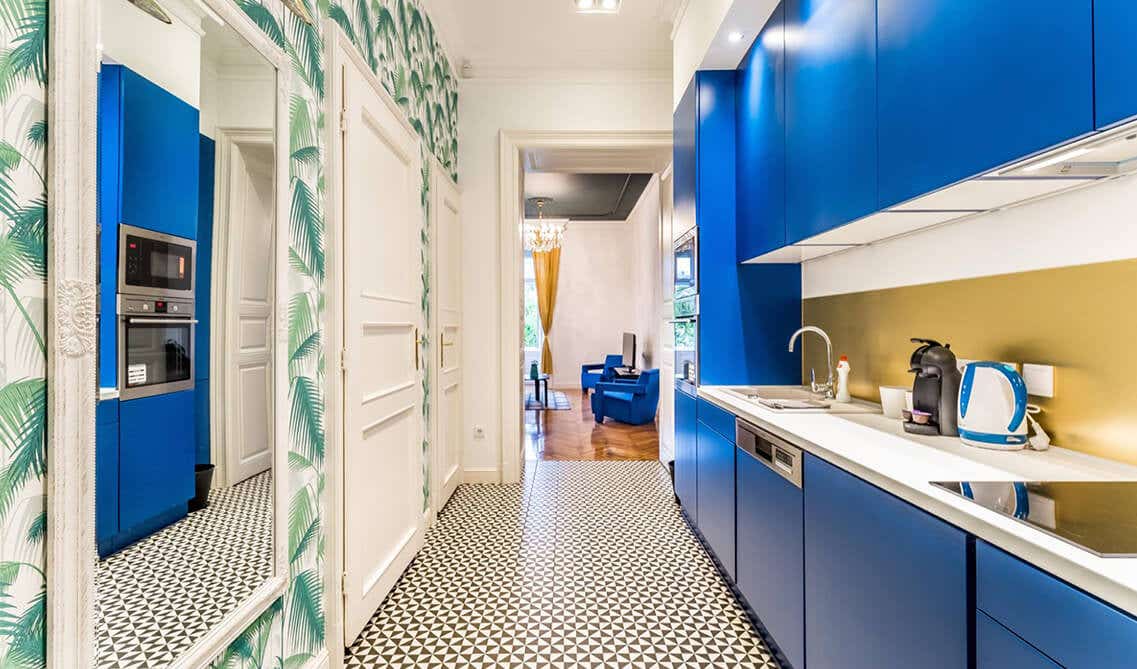 vintage kitchen with blue cabinets complete with bold prints, bright colors, and groovy patterned wallpaper