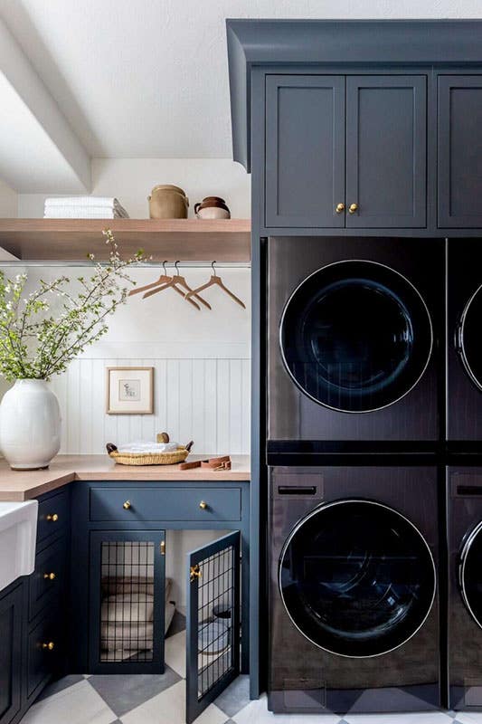 Laundry room with Navy Blue Cabinets with washer and dryer, floating shelves, and flower pot