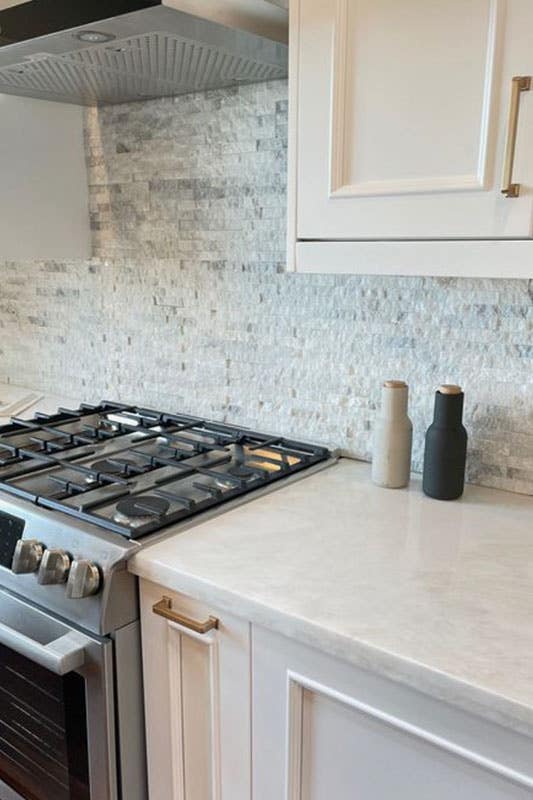 Textured Marble Backsplash with white cabinets