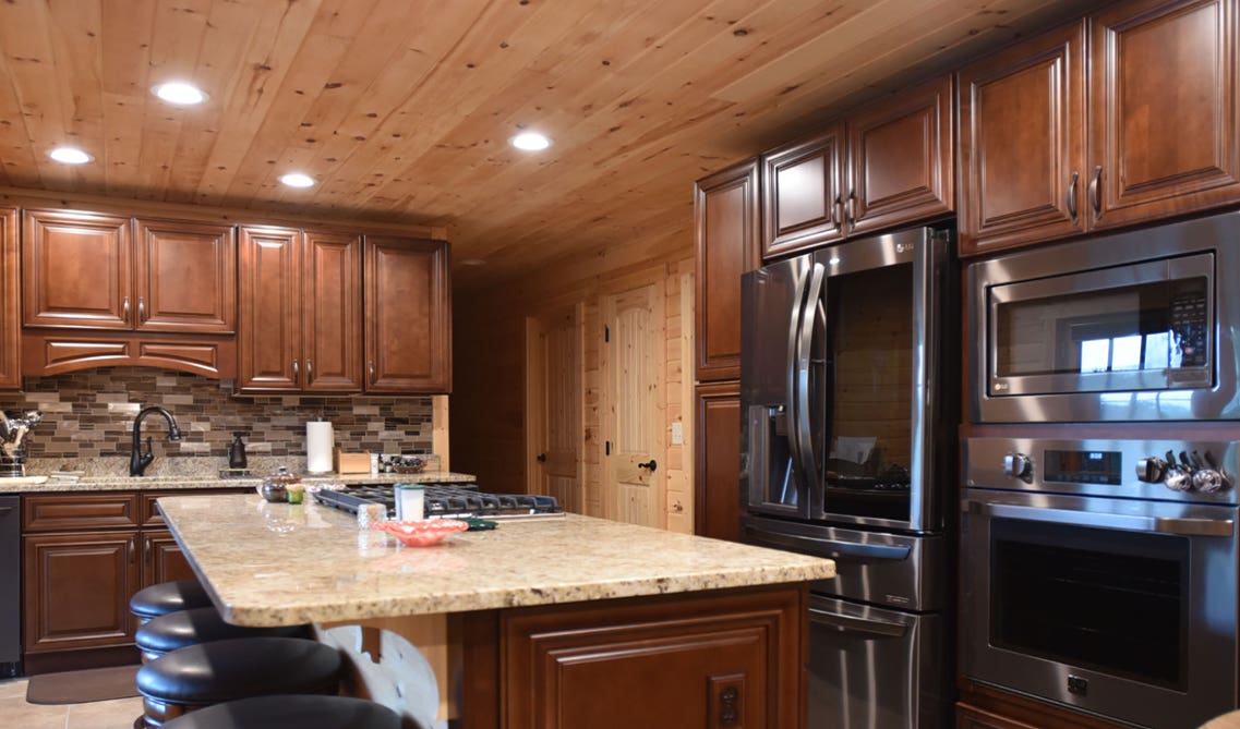 Kitchen design paired with wooden cabinets, Stainless Steel Alliances, and shiplap wall and sealing design