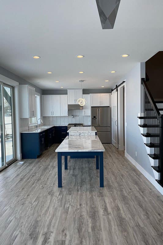 white and blue two tone cabinets with large island and stainless steel appliances 