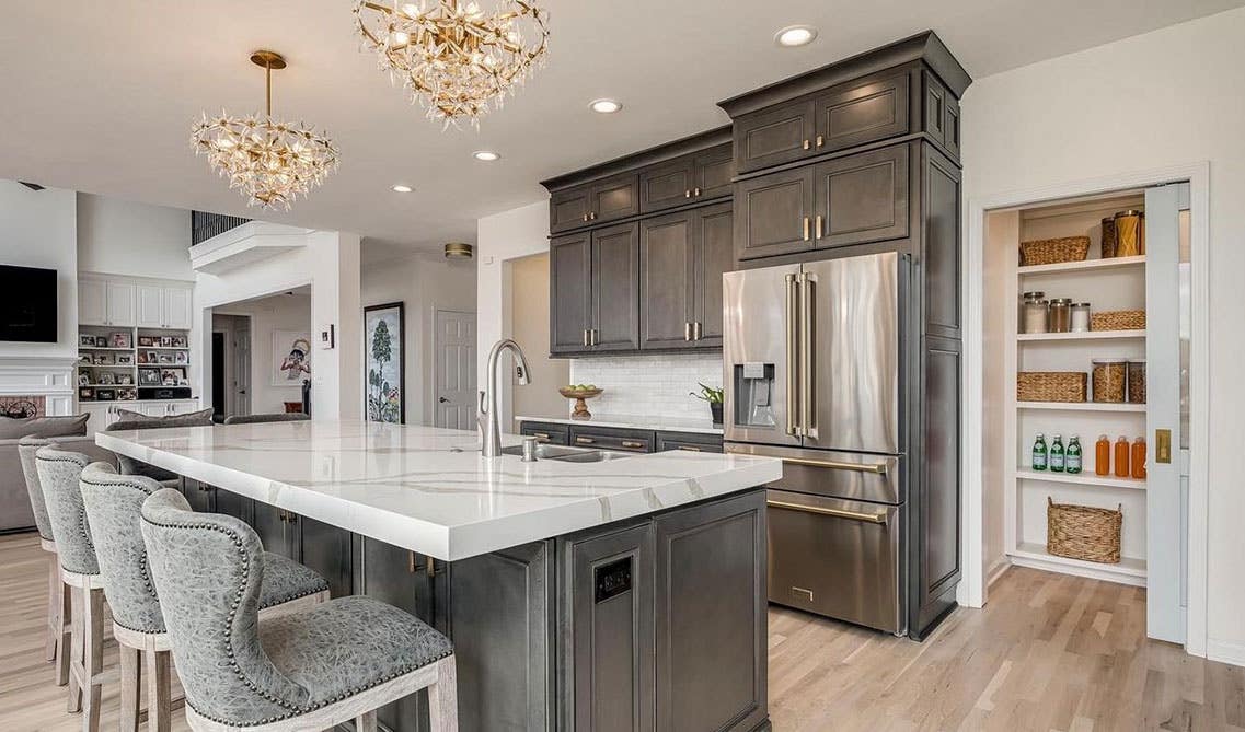 Welcoming Kitchen with large island, farmhouse style gray cabinets and stainless steel appliances