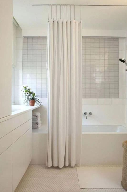 White flat panel cabinets, glossy subway tile backsplash and white modern shower curtain