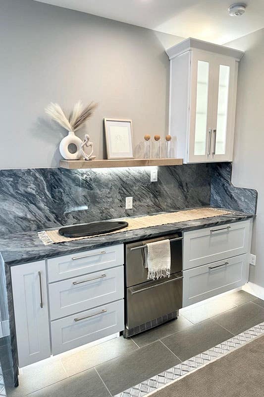 wet bar design with white cabinets and marble countertop