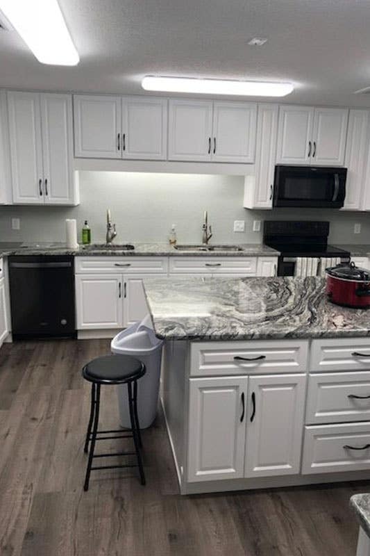 white cabinets with black hardware and marble countertop 