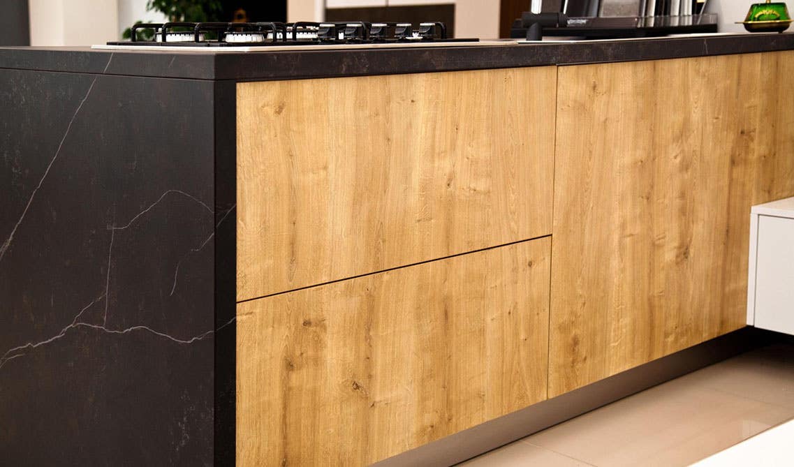 White oak hardwood cabinets with black waterfall countertop